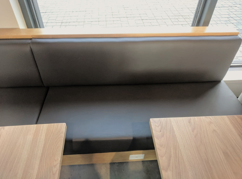 Comfortable restaurant bench with soft gray upholstery material